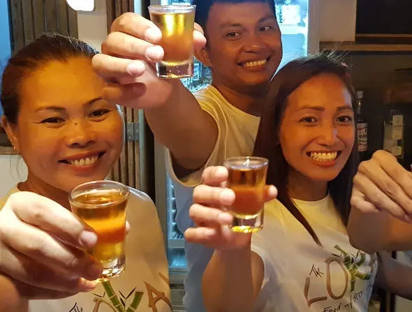 Friendly Bar Staff Raising a Shot Glass at Lokal Hotels Dauin